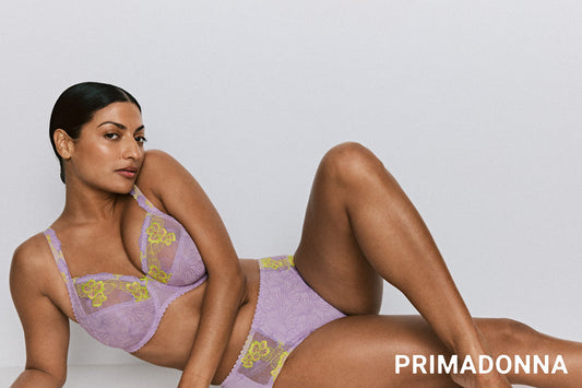 Primadonna Ixia in Wisteria lingerie model posing in purple and yellow lace lingerie set.