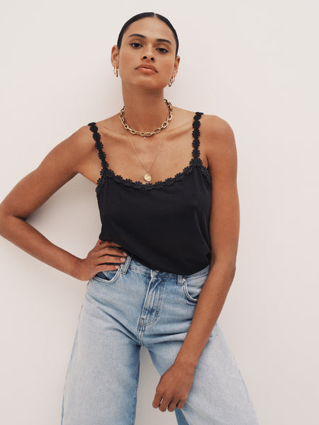 Woman wearing a black camisole from the Marie Jo Soft Studio collection with stylish denim jeans.
