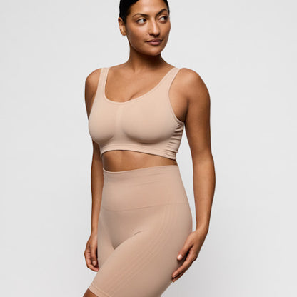 Primadonna Nudda shapewear high briefs with legs in caffe latte on a model standing confidently in a nude outfit.