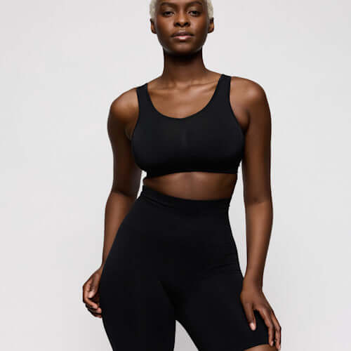 Model wearing Primadonna high briefs shapewear and a black crop top, showcasing comfort and style.