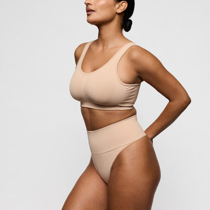 Primadonna Nudda high-waisted shapewear thong on a model, featuring smooth shaping and a caffé latte color.