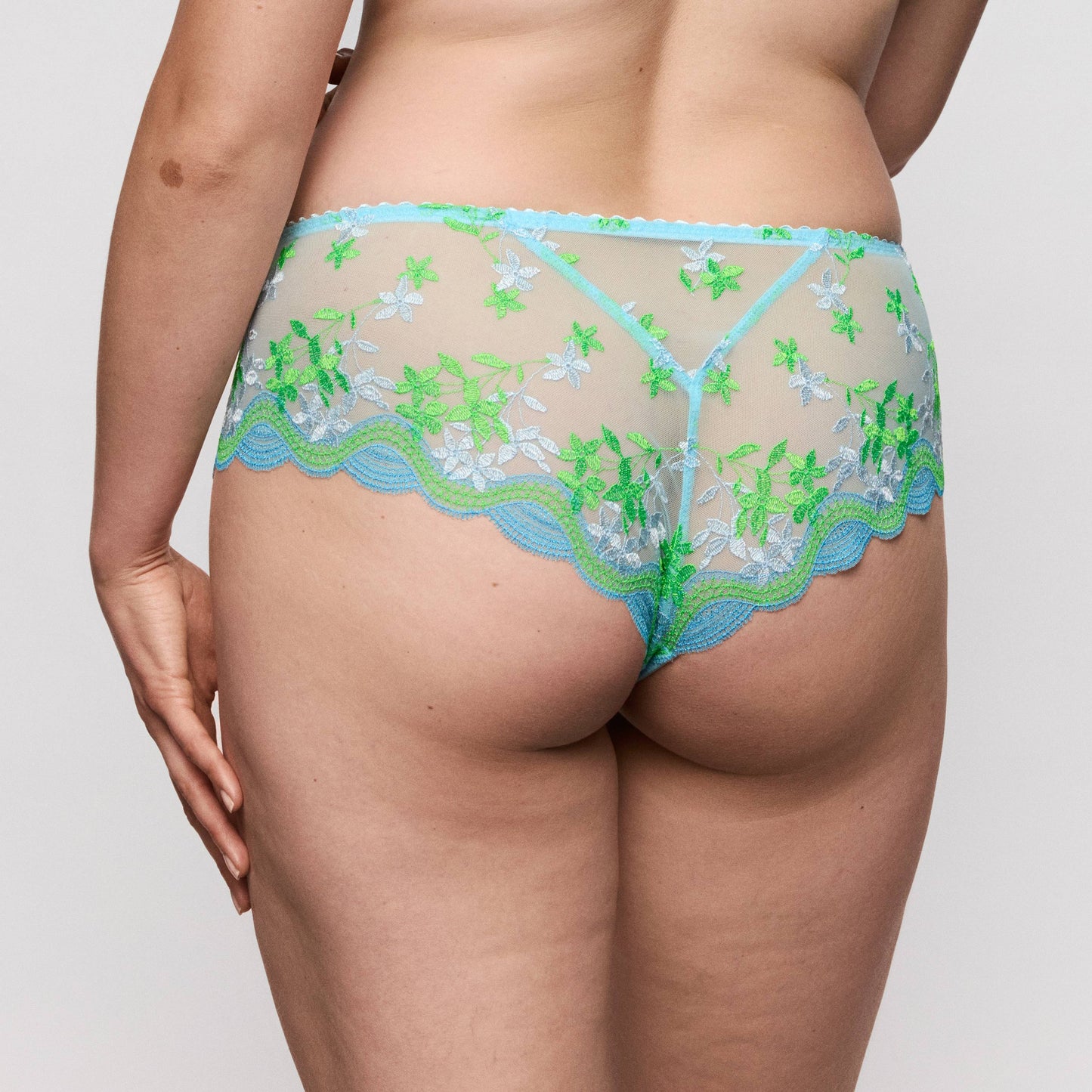 Primadonna CALA LUNA luxury thong in Ice Dream displayed from the back, featuring floral embroidery in blue and green.