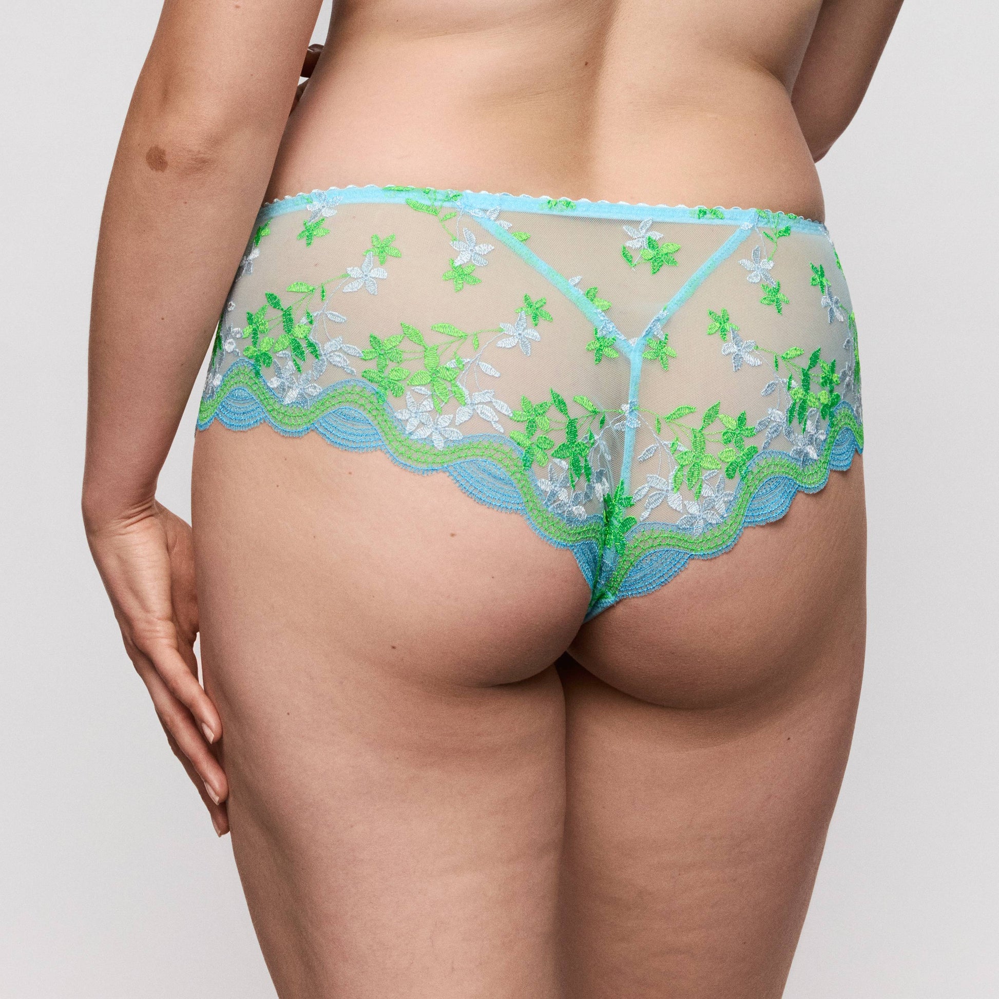 Primadonna CALA LUNA luxury thong in Ice Dream displayed from the back, featuring floral embroidery in blue and green.